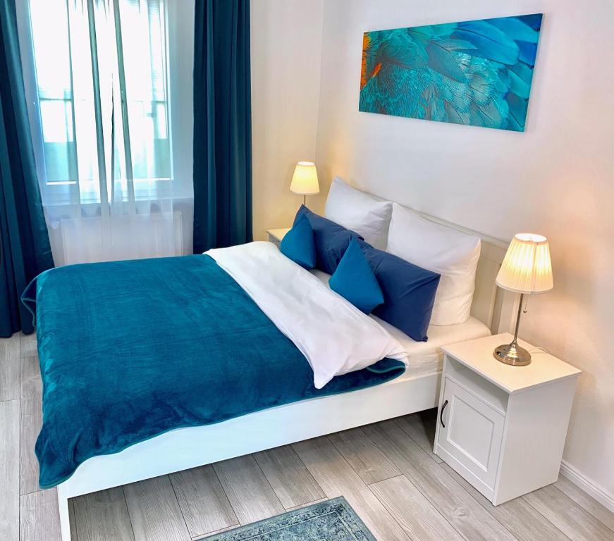 莱茵河畔林茨Im kleinen Stil l的一间卧室配有一张带蓝色枕头的大床