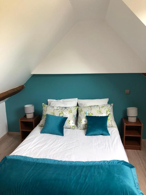 CourbouzonLes gîtes de Joséphine proche Chambord的一间卧室配有一张带蓝色墙壁和枕头的床