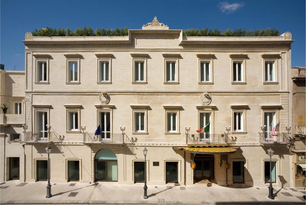 莱切Risorgimento Resort的一座大型白色建筑,设有两个阳台
