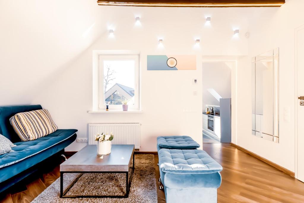 维尔纽斯Stylish, modern apartment near Vilnius Old Town的客厅配有蓝色的沙发和桌子