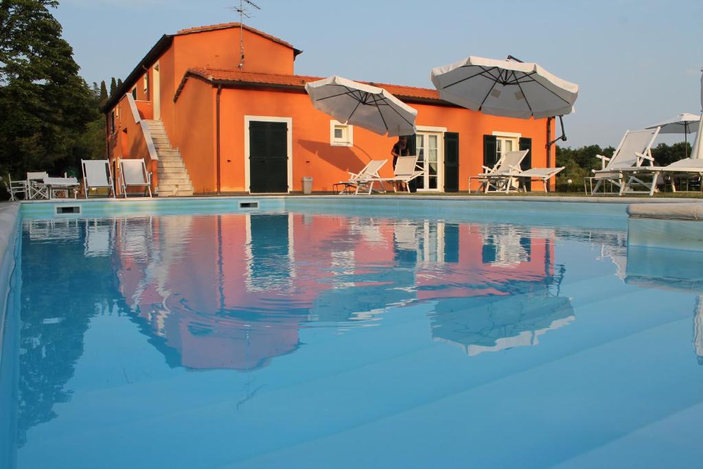 萨尔扎纳卡萨利罗梅酒店的一座带橘子屋和遮阳伞的游泳池