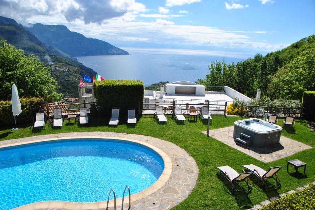 圣安吉洛维塔纳别墅酒店的后院设有游泳池和桌椅