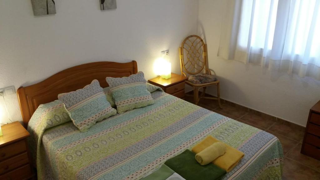 普拉加德阿罗勒斯帕尔玛雷斯公寓的一间卧室配有一张床,上面有两条毛巾