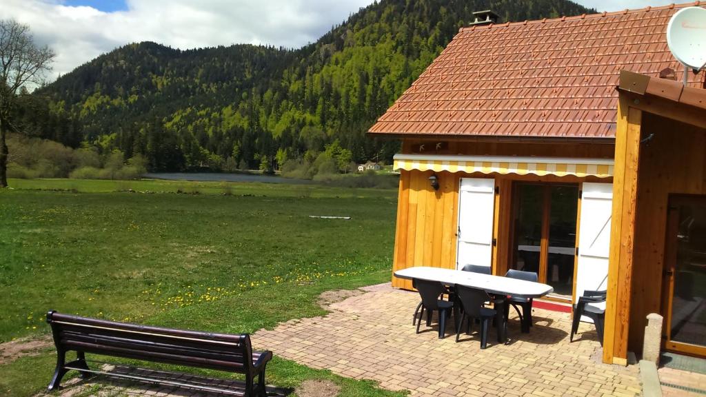 克松吕-隆日梅Chalet pour amoureux de la nature avec vue sur le lac de Retournemer的一座带野餐桌和长凳的建筑