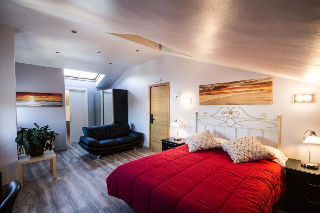 毕尔巴鄂毕尔巴鄂利亚德酒店的一间卧室配有红色的床和椅子