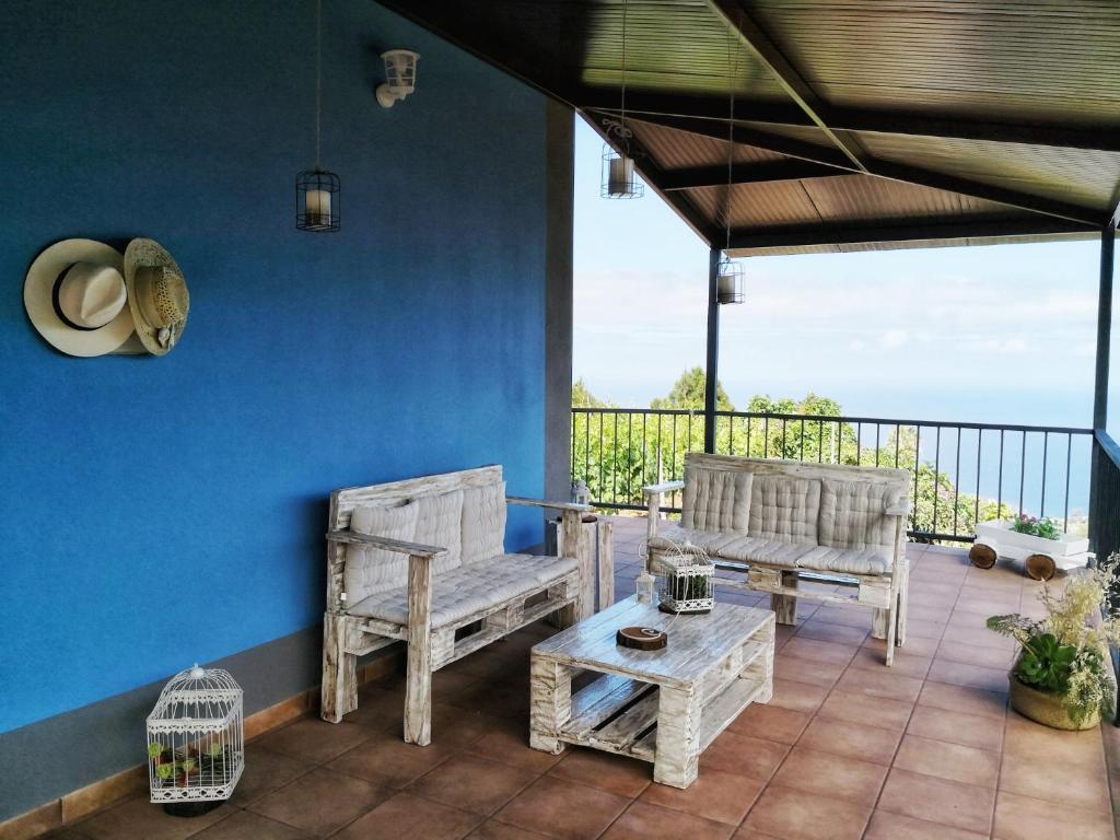 圣克鲁斯-德拉帕尔马Casa El Obispo的一个带两把椅子和一张桌子的蓝色墙壁庭院
