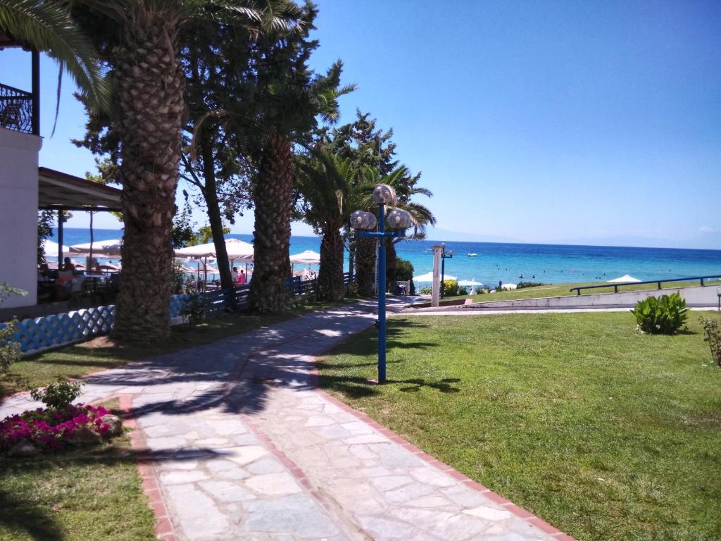 希维利siviri pliades!的棕榈树海滩和大海附近的步行道