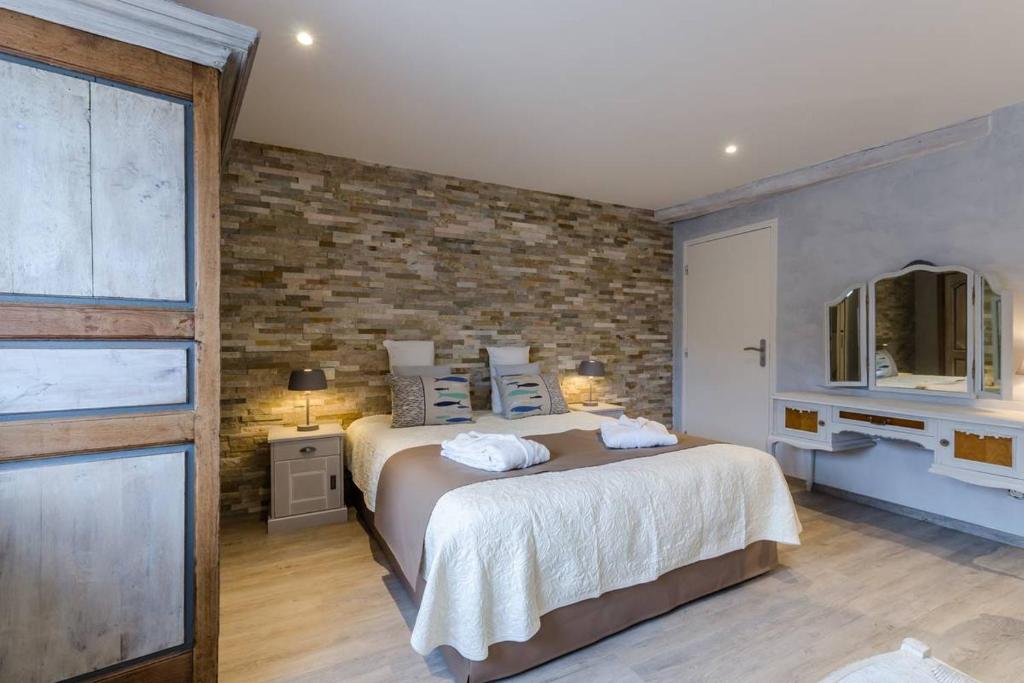 Balnot-sur-LaignesLes 3 cépages的一间卧室设有一张大床和砖墙