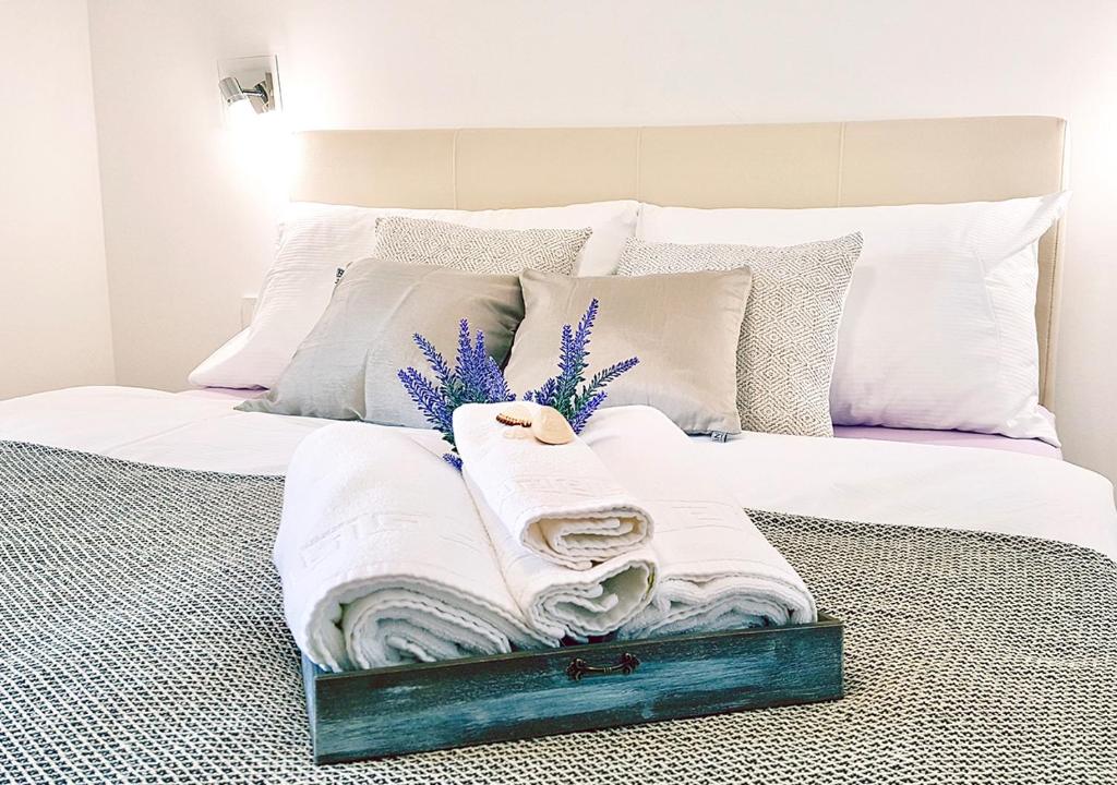 帕什曼Orkula Apartments的一张带白色床单和毛巾的床
