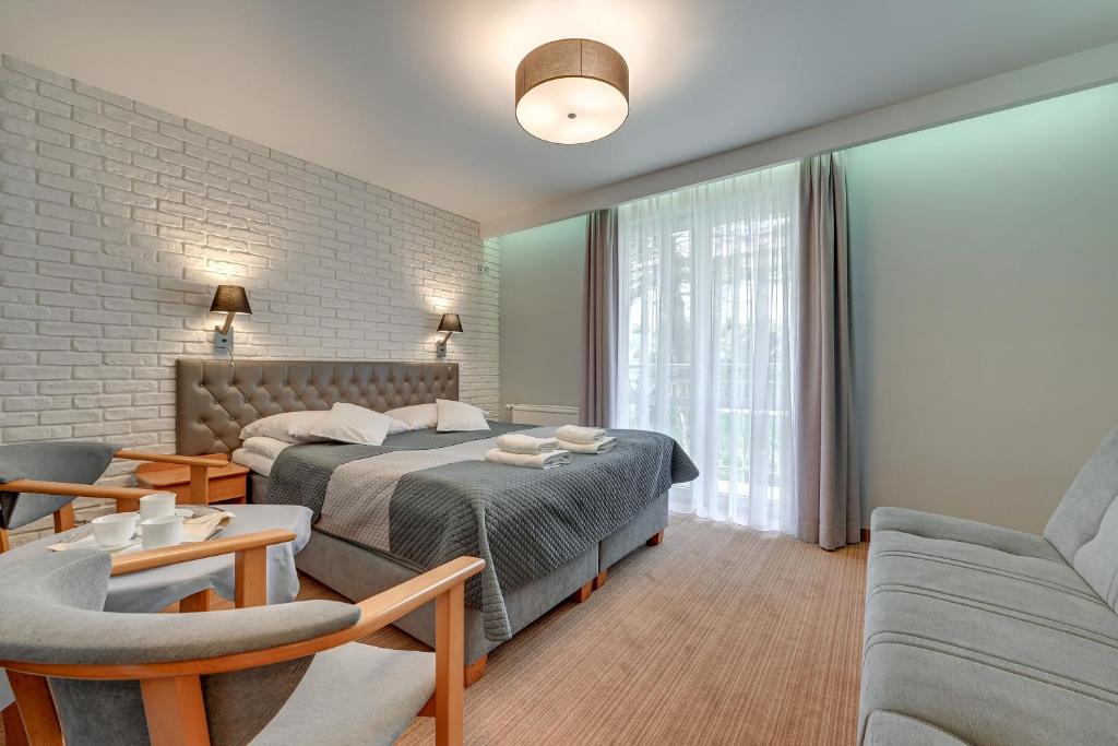弗瓦迪斯瓦沃沃Aster的一间卧室设有一张床和一间客厅。