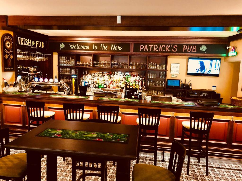 马里博尔Patrick's Pub的餐厅内的酒吧配有桌椅