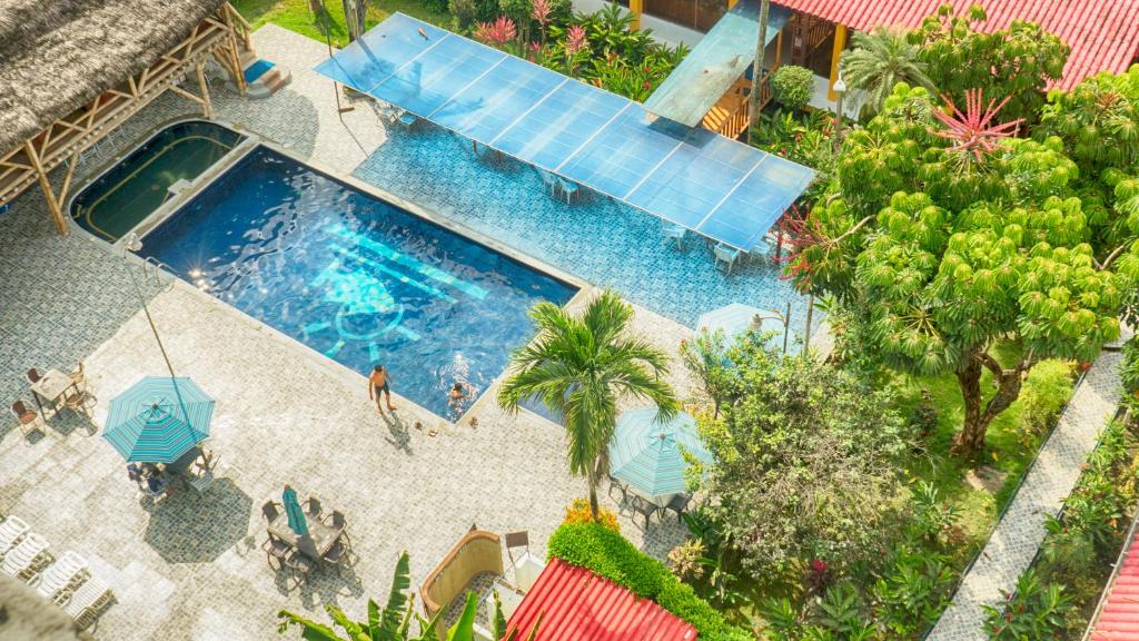 通苏帕芭叶塔港酒店的享有带人员和遮阳伞的游泳池的顶部景致