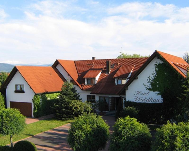 胡根尔舍姆Hotel Waldhaus的一座带橙色屋顶的大房子