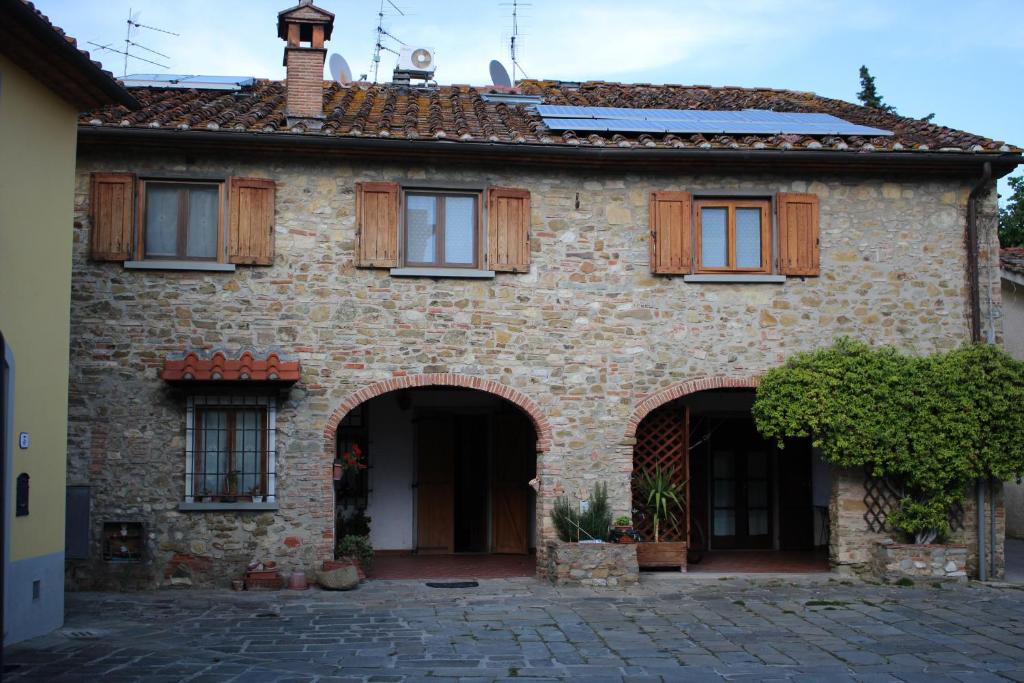 卡尔米尼亚诺Residence S.Cristina的一座带木窗和庭院的老砖屋