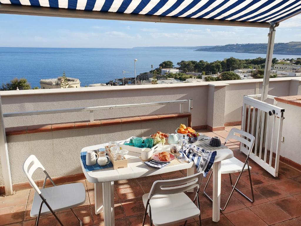 圣凯撒利亚温泉Casa con terrazza vista 180° sulla costa orientale的海景阳台上的桌椅