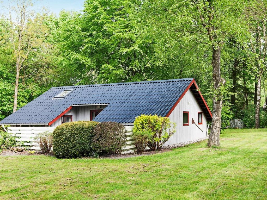 阿里尔Three-Bedroom Holiday home in Toftlund 27的白色和红色的房子,拥有太阳能屋顶