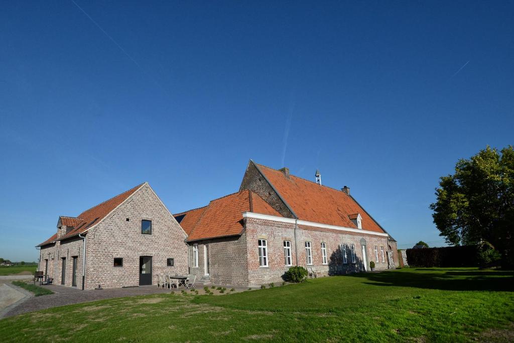 Sint-DenijsHoeve Ten Rooden Duifhuize的一座红屋顶的大型砖砌建筑
