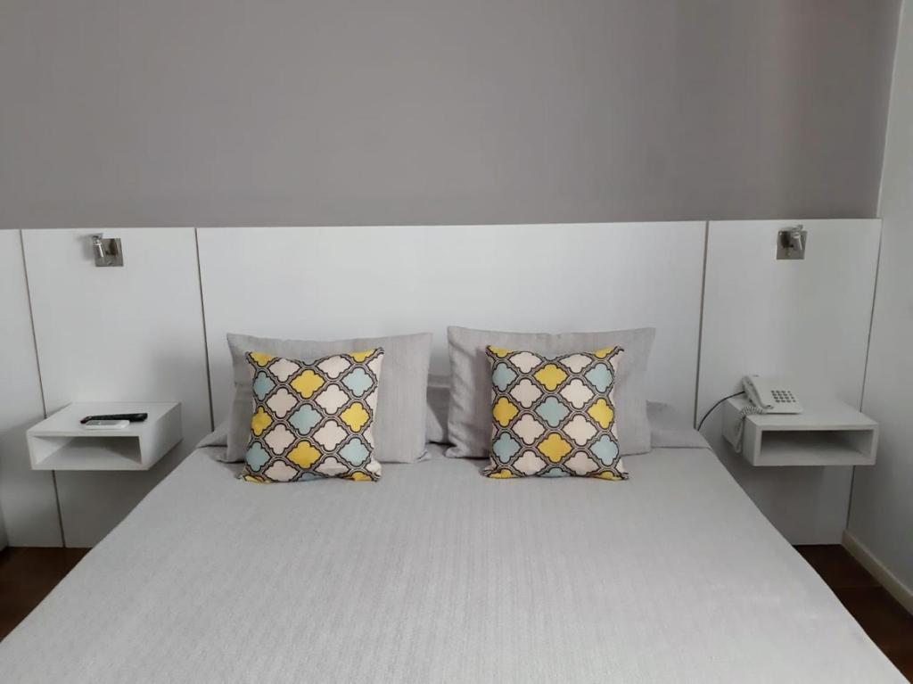 图努扬Hotel Tunuyan的卧室配有带枕头的白色床