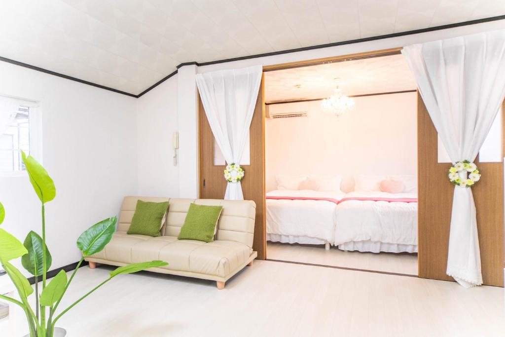 四日市9 min to Yokkaichi Tomida STN House的一间带镜子、一张沙发和一张床的卧室