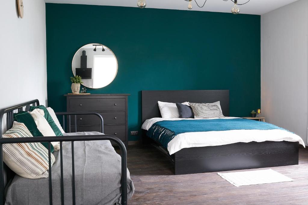 尤尔马拉Greenhouse Apartments的一间卧室设有绿色的墙壁、一张床和镜子