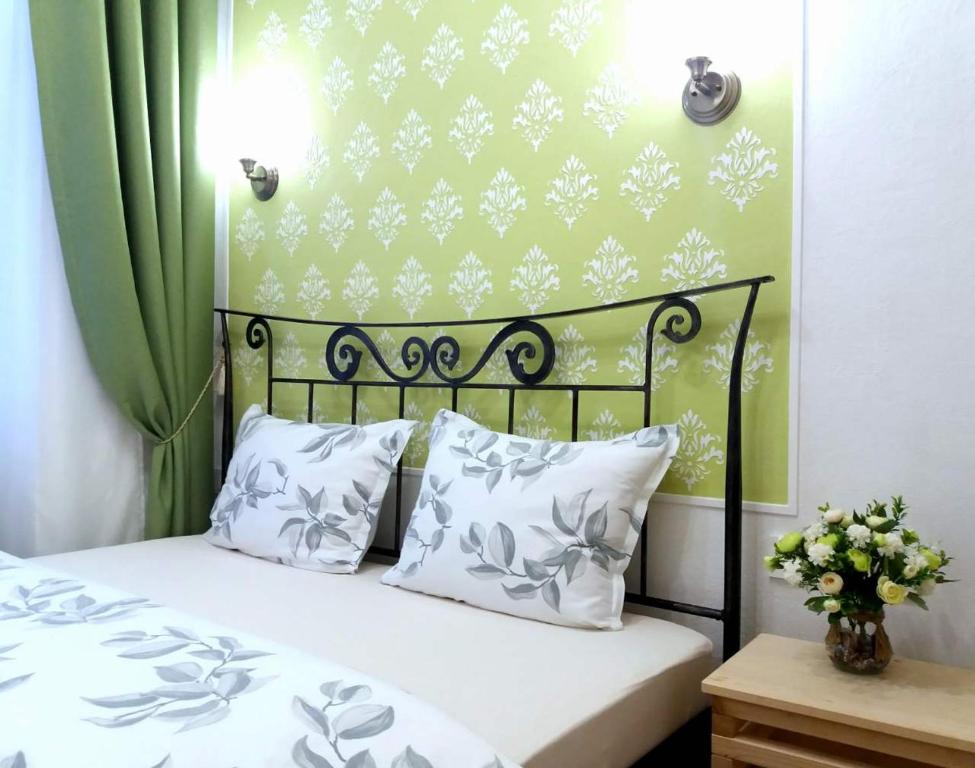 伊佐拉Guest House Izola的一张带白色枕头和绿色墙壁的床