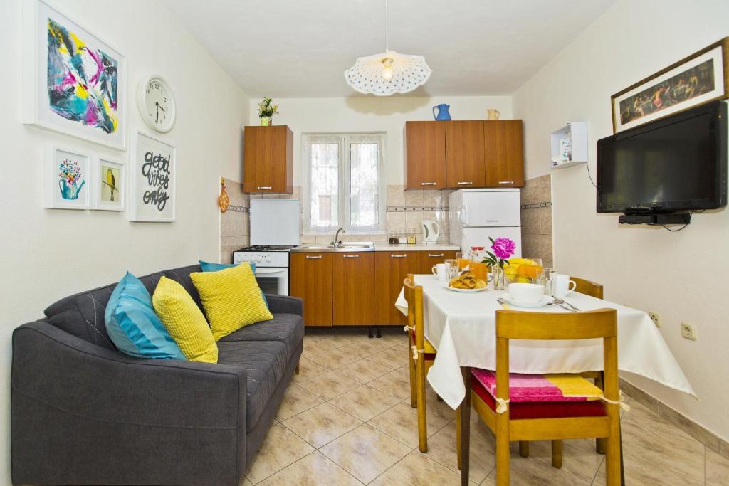 赫瓦尔Lina Vranković Apartments的一间带桌子和沙发的客厅以及一间厨房。