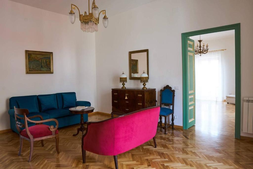 PietraperziaDimora Liberty autentica sicilianità的客厅配有蓝色的沙发、桌子和椅子