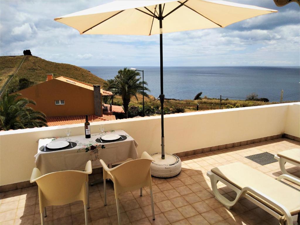 卡尼索Beachfront House Atalaia的一个带桌子和遮阳伞的庭院