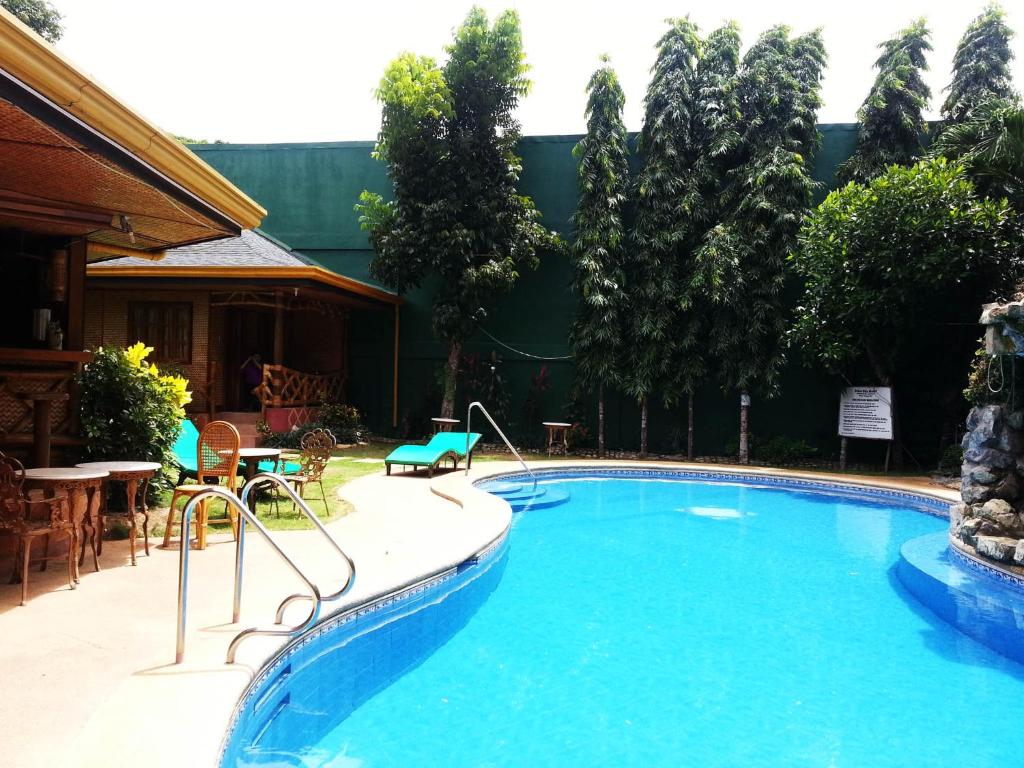 公主港快乐之源酒店的一座大游泳池,位于一个树木繁茂的庭院内