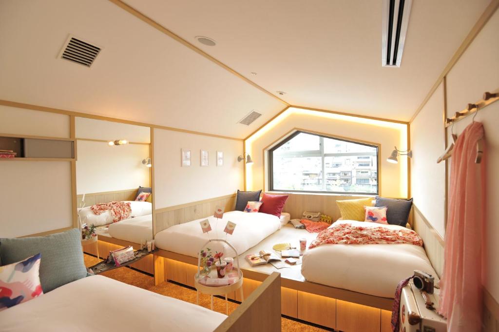 京都咖啡淘京都三条女士旅馆的客房设有两张床和窗户。