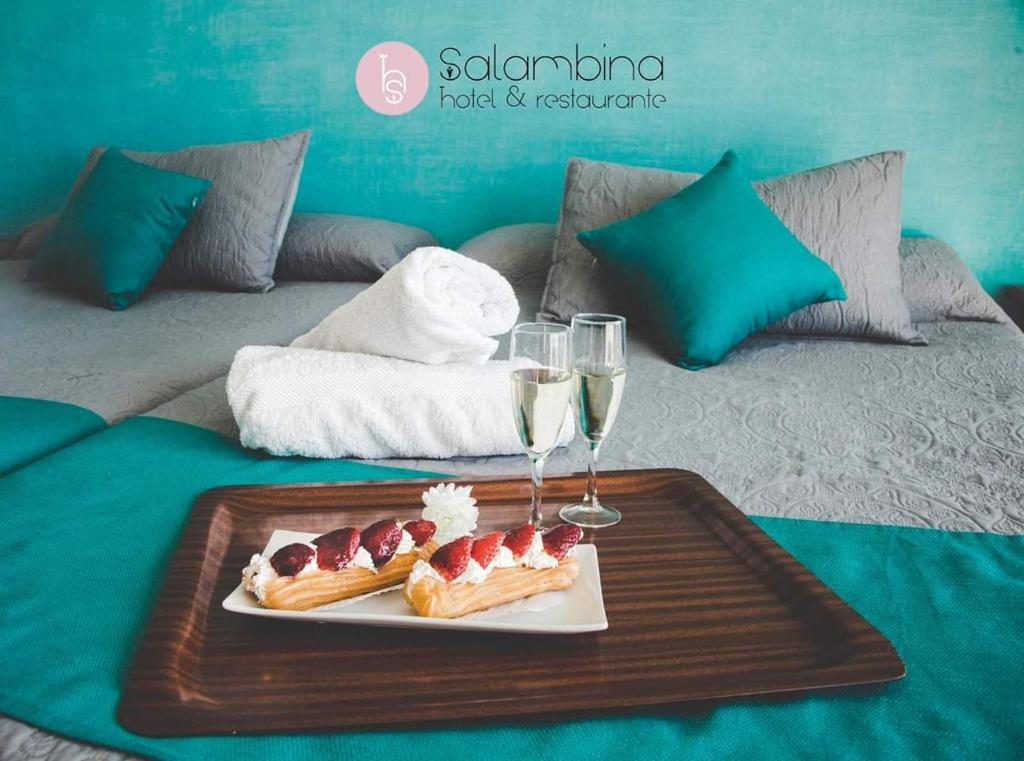 萨各夫雷纳Hotel Salambina的盘子,盘子上放着一盘食物和酒杯