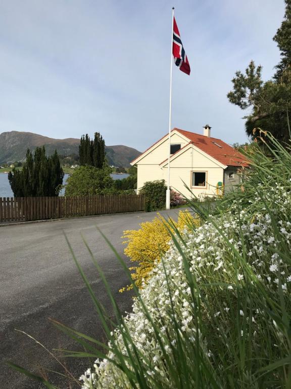 SeljeSkogstad Holiday Home的路边有旗帜的房子