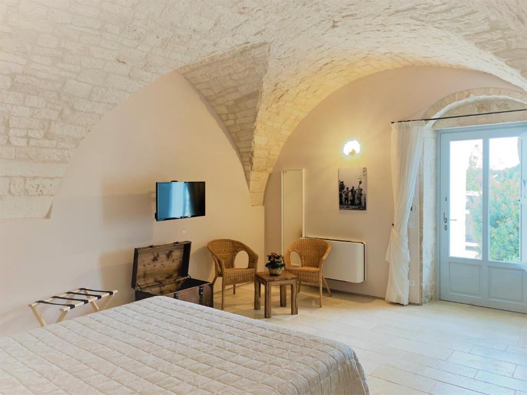 洛科罗通多Masseria Grofoleo的一间卧室配有一张床,墙上配有电视