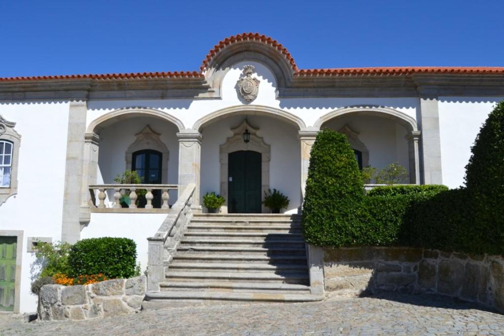 曼瓜尔迪Solar de Almeidinha的前面有楼梯的白色房子