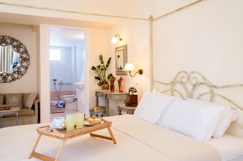 阿基欧斯尼古拉斯Ikaros Art Hotel的卧室配有白色的床和带蜡烛的桌子。