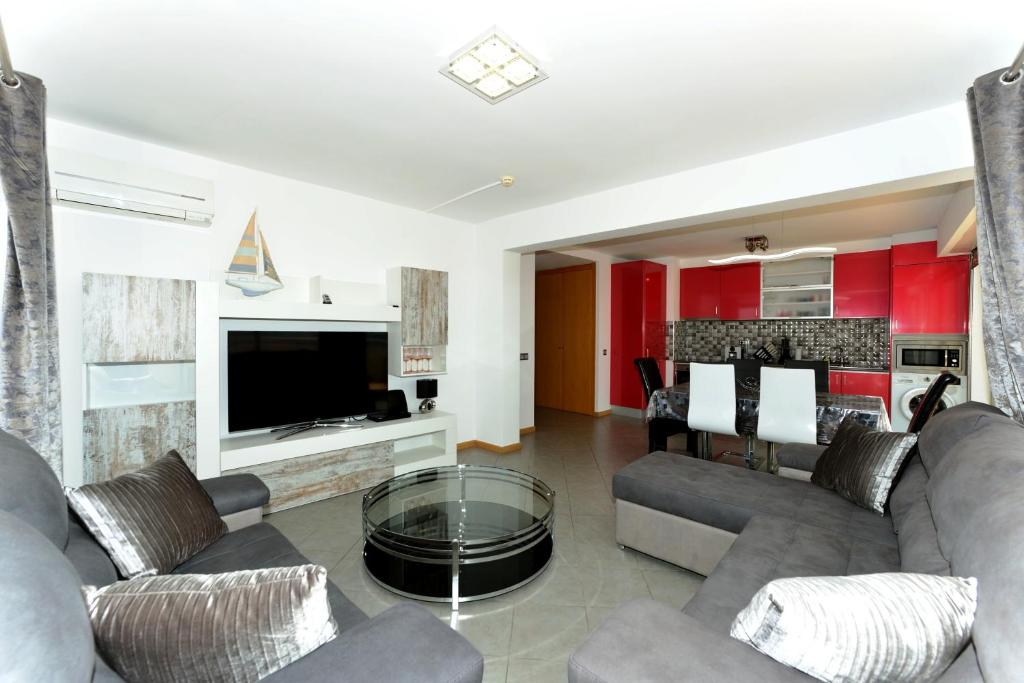 波尔蒂芒Exclusive Luxury Apartments in Oceano Atlantico Complex的带沙发、电视和桌子的客厅