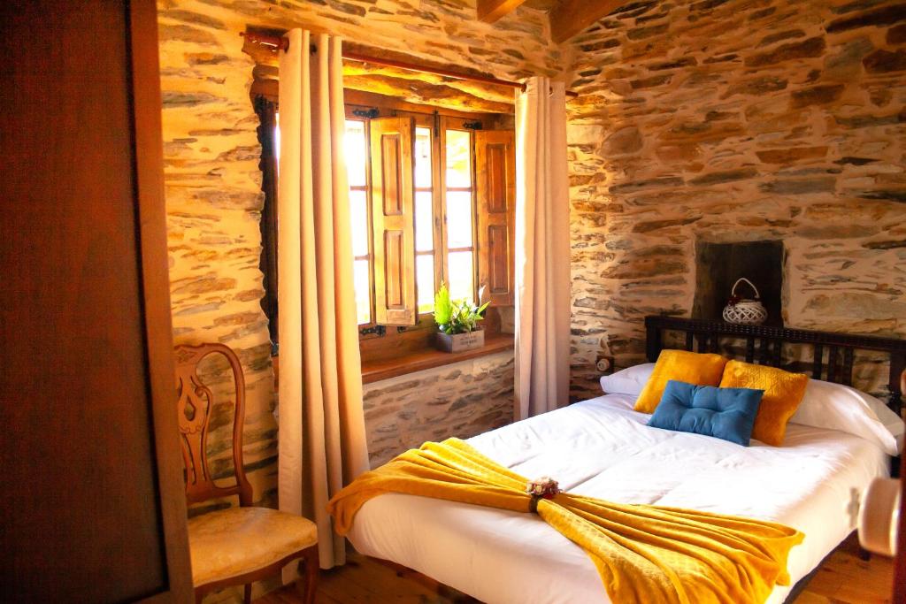 Valle de FinolledoCASA RURAL BIERZO ENCANTADO的一间卧室配有一张黄色毯子床