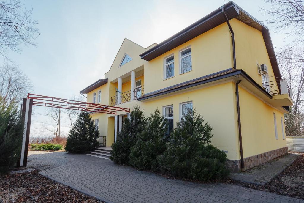 敖德萨Гостевой дом писателей的前面有树木的黄色房子