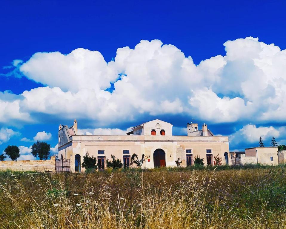 切萨雷奥港Masseria Casina Bellanova的一片云天的田野中的一座老房子