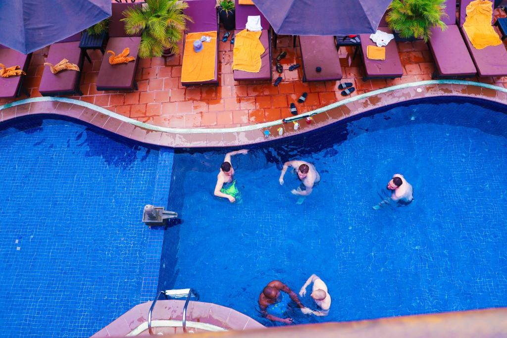 暹粒欧卡1别墅酒店的一群人在游泳池游泳