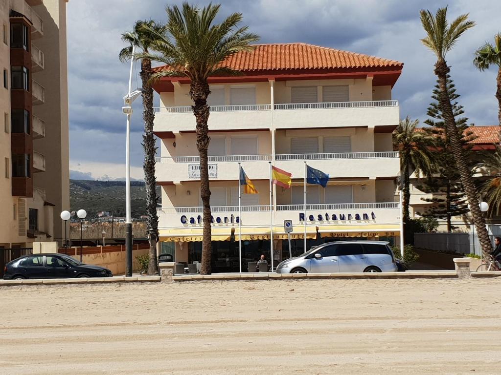佩尼斯科拉Precioso Apartamento的前面有两辆车的酒店