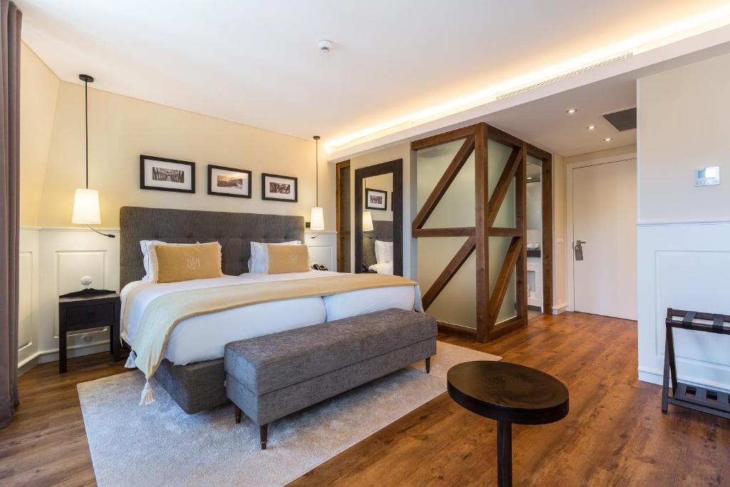 里斯本里斯本葡萄酒酒店的一间大卧室,配有一张大床和一张桌子