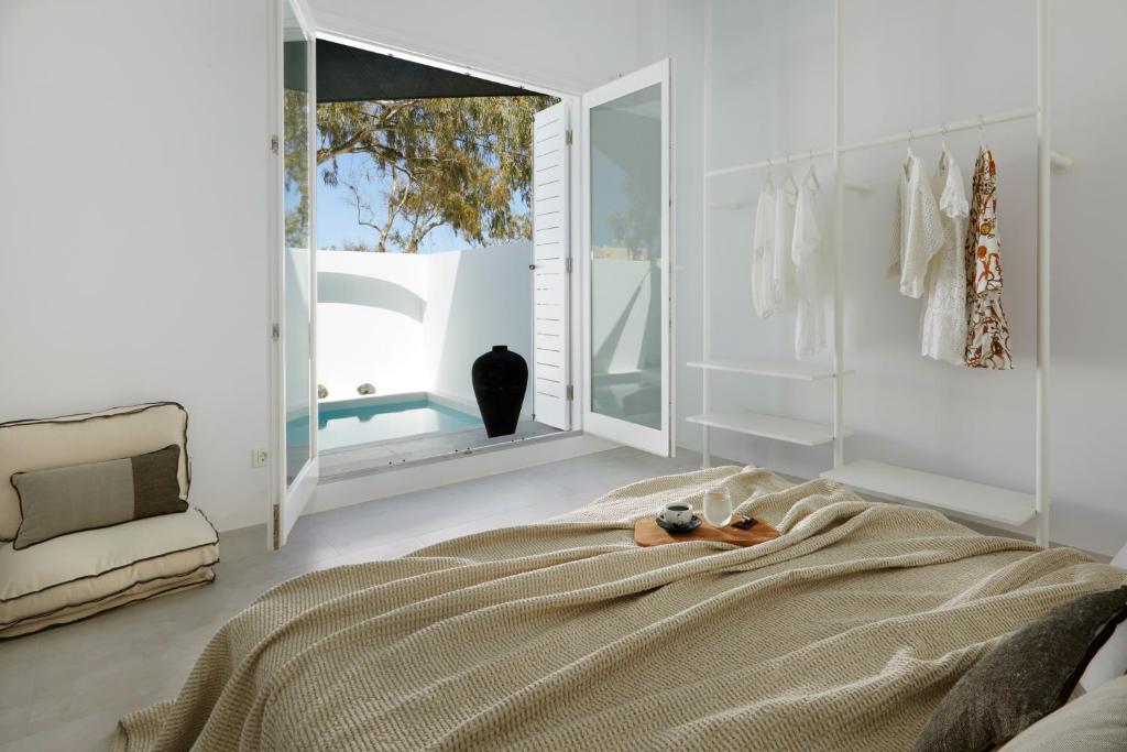 梅萨雷亚Le Blanc Nest Santorini - Family / Couples Luxury House的一间卧室配有一张大床和镜子