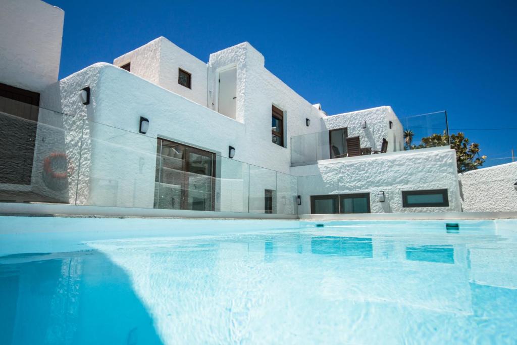 阿格特Las Nieves Blue的一座白色的房子,前面设有一个游泳池