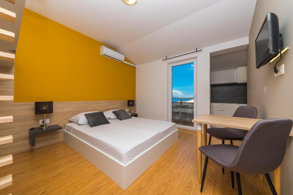 巴什卡沃达Apartments Gavran的一间卧室配有一张床、一张书桌和一台电视。