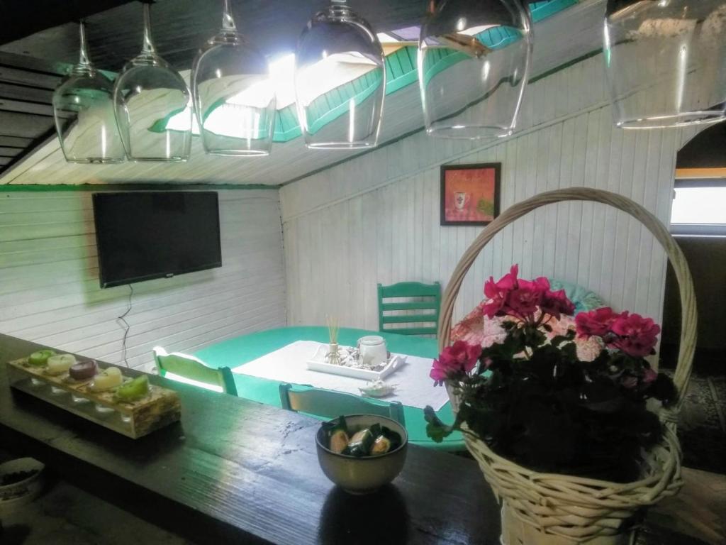 弗尔沙茨Potkrovlje的客厅配有桌子、电视和鲜花