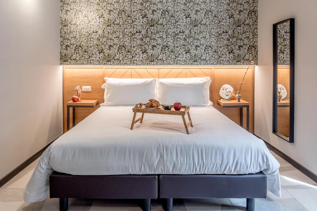 米兰APARTHOTEL CASA MIA的一间卧室配有一张大床和木制床头板