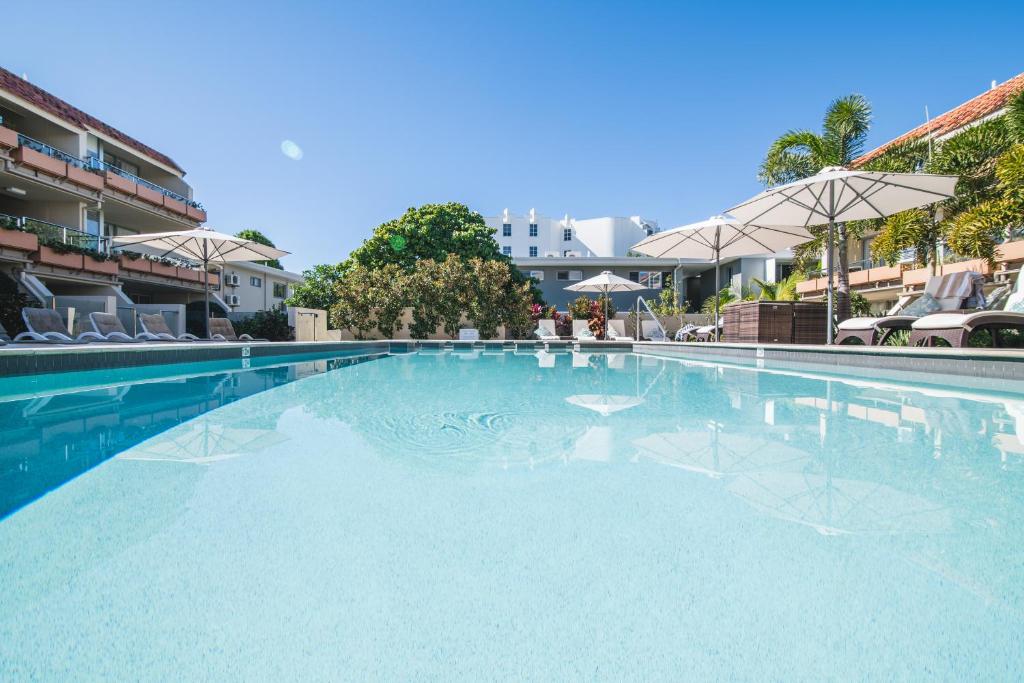努萨角拉古纳酒店的一个带椅子和遮阳伞的大型游泳池