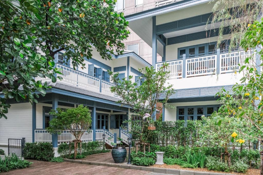 曼谷Baan Vajra的公寓大楼设有阳台和树木