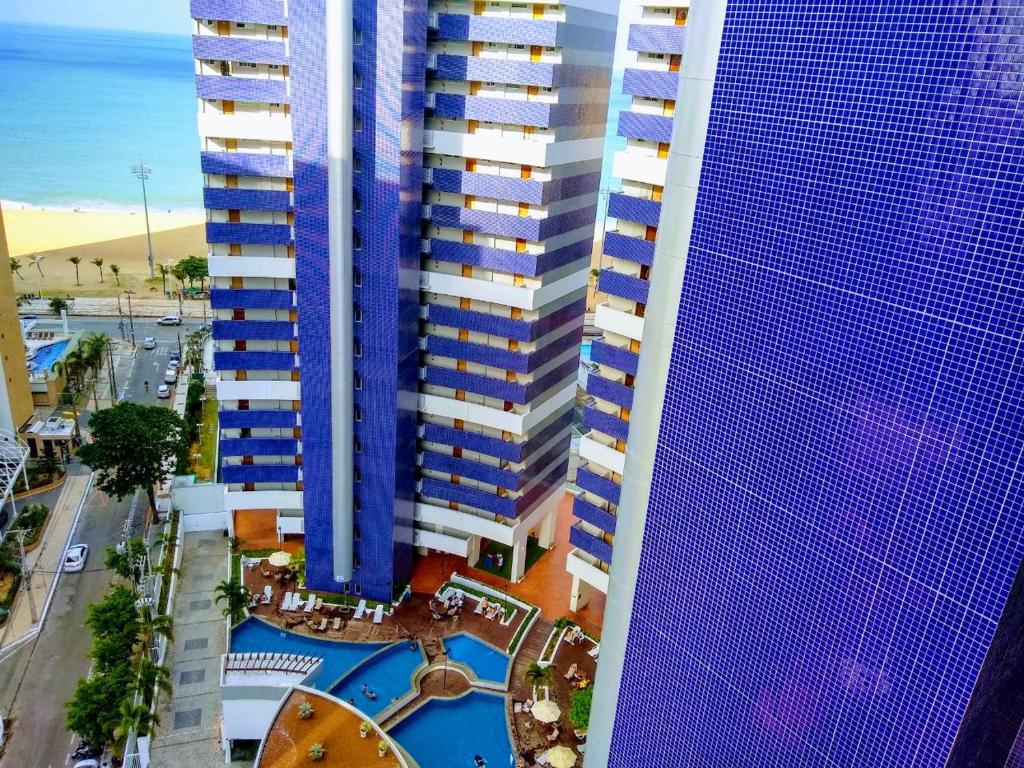 福塔莱萨Apartamento com 2 quartos no Beach Class Fortaleza的享有高楼和游泳池的顶部景色